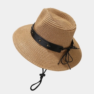 Brown straw cowboy hat with vintage bull head decor and black leather studded band