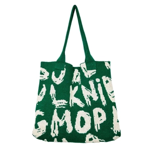 Macro detail of forest green and beige knitted tote bag with textured lettering