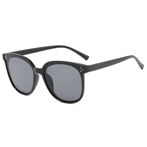 Detail of black oversized sunglasses showing three silver dots on a sleek resin frame