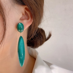 Elegant vintage emerald green teardrop earrings shown on a model side profile