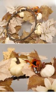 Detail of autumn wreath with maple leaves, cream pumpkins and vintage vine base