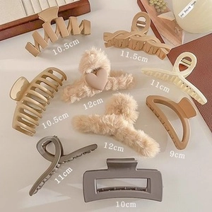 Detail showing various sizes of large hair clips in matte and plush materials for women