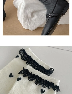 Detail of white cotton socks featuring black lace trim and heart patterns with Mary Janes