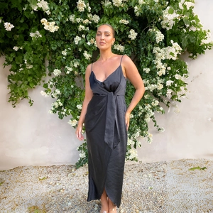 Détail de l'élégante robe longue en satin noir avec col en V et ceinture nouée à la taille