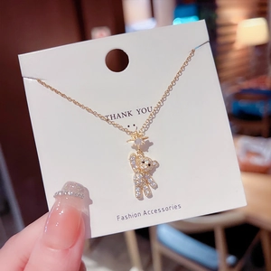 Close-up of golden bear pendant necklace with sparkling crystals on a display card