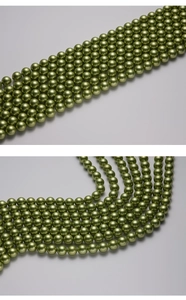 Detailed view of high-luster green Tahiti style shell pearls with smooth metallic finish