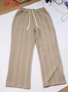 Detailansicht der beigefarbenen Strickhose mit Zopfmuster und Kordelzug am Bund