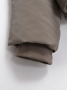 Close-up of windproof ribbed cuffs on a taupe hooded puffer jacket for winter