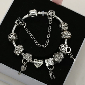Macro shot of silver charm bracelet with heart lock, key and I love you engraving
