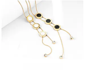 Macro shot of gold snake chains featuring Roman numeral pendants and hanging zirconia