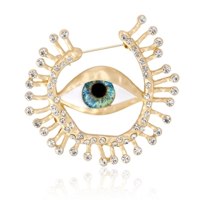 Broche œil vintage en alliage doré avec pupille bleue et strass étincelants sur blanc