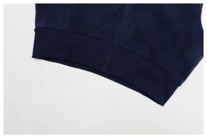 Détail de l'ourlet côtelé et de la fermeture éclair sur un gilet de sport bleu foncé