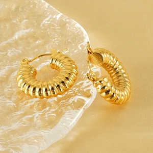 Elegant 18k gold plated stainless steel chunky spiral hoop earrings on champagne silk