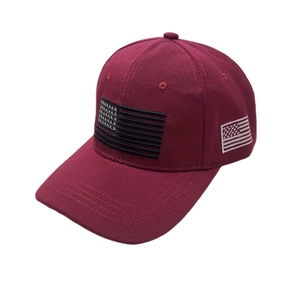 Detail of embroidered American flag patches on a burgundy cotton twill baseball cap