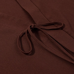 Détail de la texture en lin marron foncé avec un nœud à la taille sur le vêtement