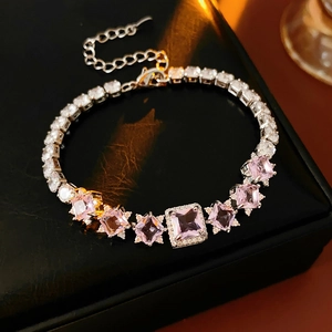 Close-up of sparkling cubic zirconia chain bracelet with pink gems on black leather