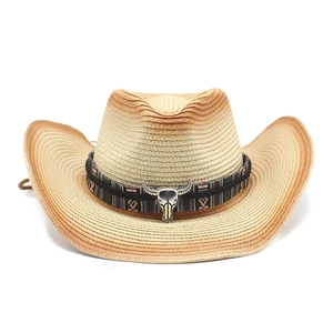 Chapeau de cowboy en paille avec bande ethnique et boucle tête de taureau sur fond blanc