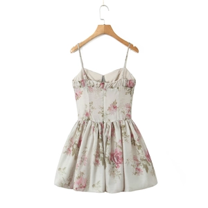 Dettagli di mini abito con stampa a rose, spalline sottili e bordo su gruccia in legno