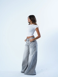 Classici jeans grigi a vita alta a gamba larga e top corto bianco mostrati su una modella