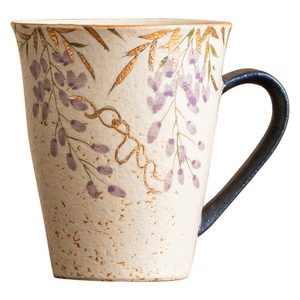Hand-painted ceramic mug with wisteria floral pattern, gold accents, and a blue handle