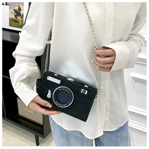 Close-up of a creative retro camera shape crossbody bag with black glitter and silver chain