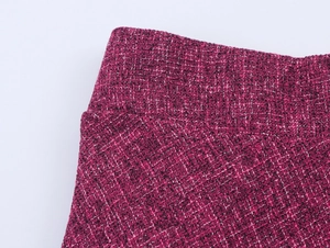 Close-up of elegant magenta tweed fabric texture with woven black and white yarn detail