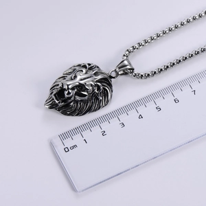 Silver lion head pendant in stainless steel with chain shown next to a measuring ruler