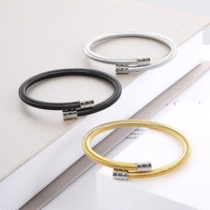 Detailed view of flexible steel cable bangles in gold, black, and silver finishes