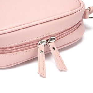 Detail of light pink leather bag featuring double zippers with silver metal rivets