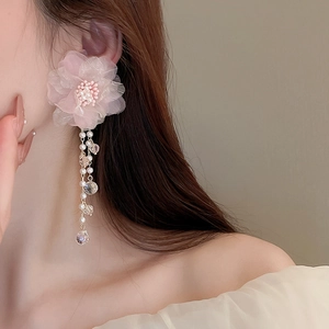 Detail showing pink lace flower earrings with long pearl and crystal tassel on model