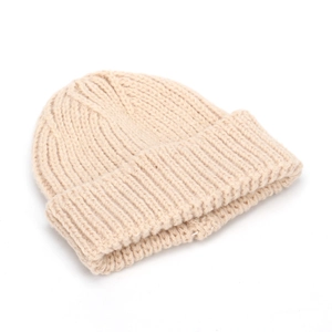 Dettaglio ravvicinato della trama di un berretto in maglia beige con risvolto alla moda.