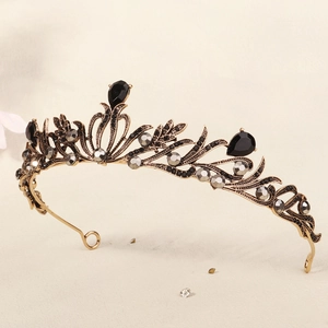 Macro detail of black teardrop gems and grey crystals on vintage gold bridal crown