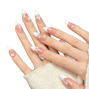 Elegant long pointed press-on nails with 3D white floral patterns and French tips
