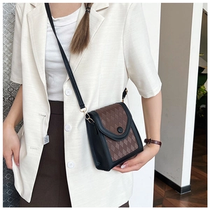 Détail du motif matelassé et de la boucle métallique sur le mini sac bicolore chic