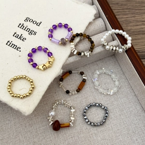 Detail of 8-piece beaded ring set with crystals and pearls on linen display tray