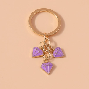 Detail of golden alloy keychain featuring three purple enamel diamond pendants