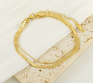 Nahaufnahme der doppellagigen 18k vergoldeten Schlangenkette und Perlenfußkette aus Edelstahl