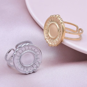 Detail of adjustable round sunburst ring in gold and silver finish on silk background