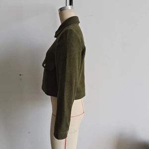 Détail de la veste en laine vert olive avec poche de poitrine à rabat et boutons pression