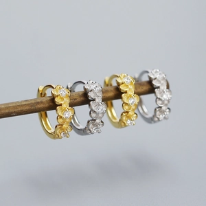 Detailed macro view of floral s925 silver earrings with matte finish and zircon inlay