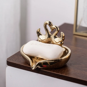 Golden swan heart ceramic soap dish on wood surface with elegant mirror finish