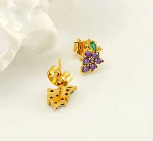 Detailed macro view of gold grape stud earrings featuring purple and green zircon stones
