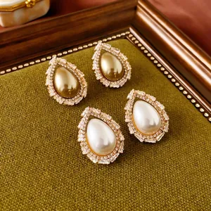 Boucles d'oreilles vintage avec perles et cristaux sur présentoir en velours vert
