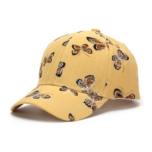 Détail de la casquette jaune avec imprimé papillon vintage et visière incurvée