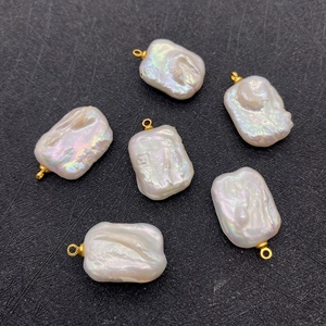 Macro detail of irregular baroque freshwater pearls with golden pendant clasps for DIY jewelry