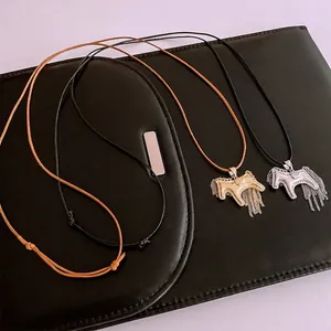 Pony fringe pendant necklace in gold and silver finish with tassel on black leather