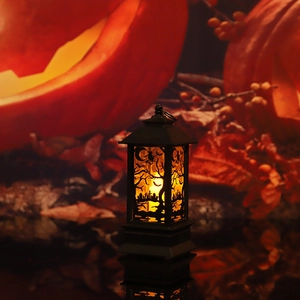 Macro shot of a black vintage Halloween lantern with witch and bat silhouette and LED candle