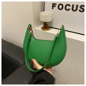 Close-up of a stylish green crescent underarm bag in smooth PU leather with metal zipper