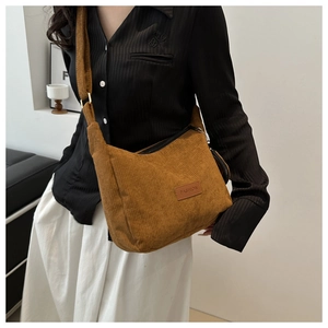 Brown corduroy shoulder bag shown on model highlighting its soft texture and large capacity