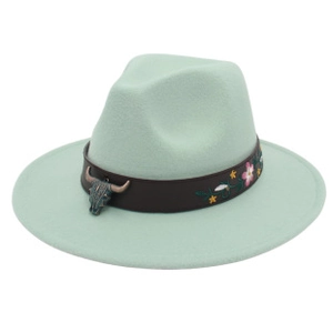 Dettaglio del cappello fedora verde menta chiaro con ricamo floreale e ciondolo testa di toro